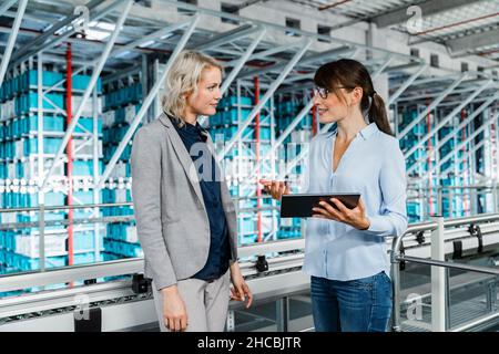 Manager having discussion with coworker in warehouse Stock Photo