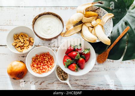 Fresh fruits and yogurt in bowls on table Stock Photo