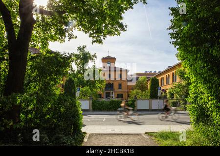 Germany, Bavaria, Munich, Two cyclists passing Lenbachhaus museum Stock Photo