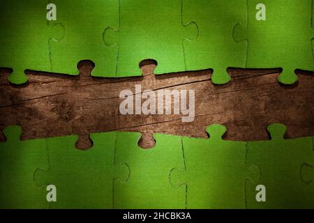 Incomplete green jigsaw puzzle pieces on table Stock Photo