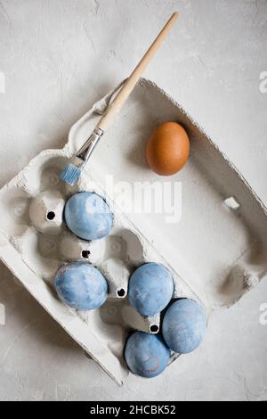 Studio shot of three chicken eggs lying with hay on wooden surface Stock Photo