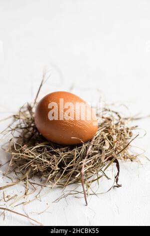 Studio shot of three chicken eggs lying on hay against white background Stock Photo