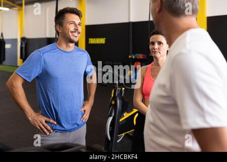 Man talking with friends in gym Stock Photo
