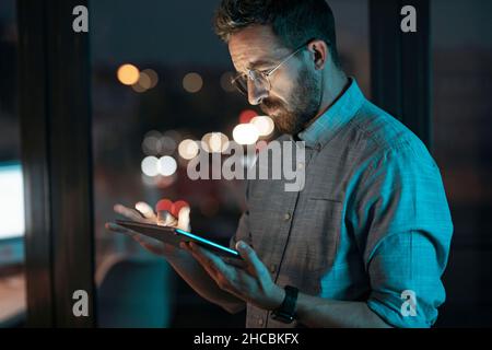Businessman working on tablet PC at late night in office Stock Photo