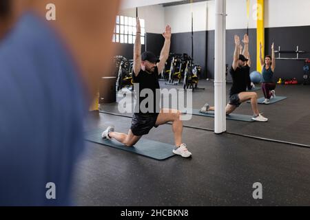 Sportswoman and friend doing stretching exercise in gym Stock Photo