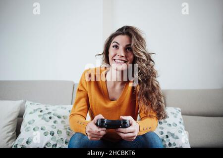 Young woman playing video game at home Stock Photo