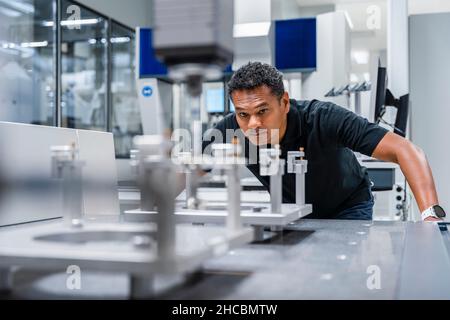 Engineer examining automated machine in factory Stock Photo