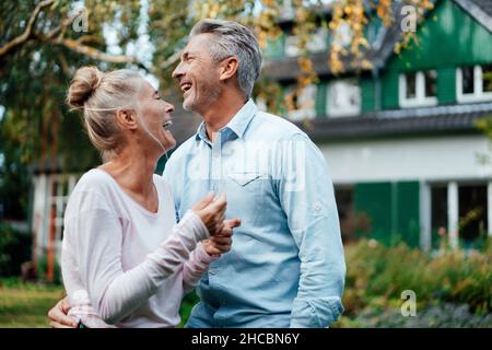 Couple sitting together on stool at backyard Stock Photo