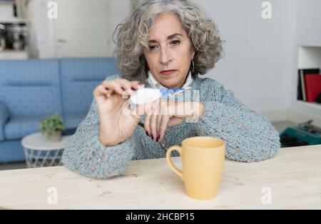 Senior woman reading tarot cards on table at home Stock Photo