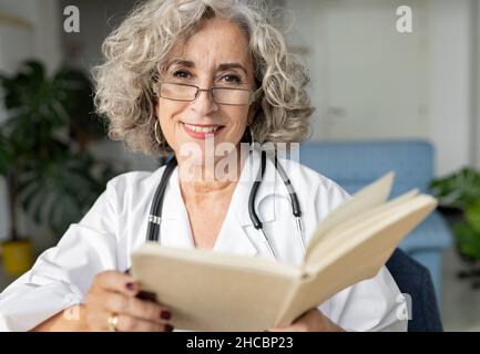 Senior senior doctor reading diary at home office Stock Photo