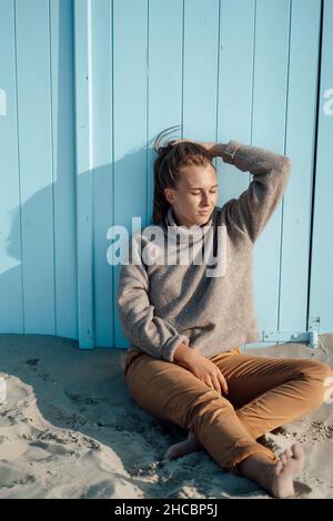 Young woman standing on sand at beach Stock Photo