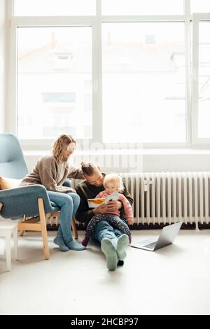 Happy family sitting inside tent using digital tablet at home Stock Photo