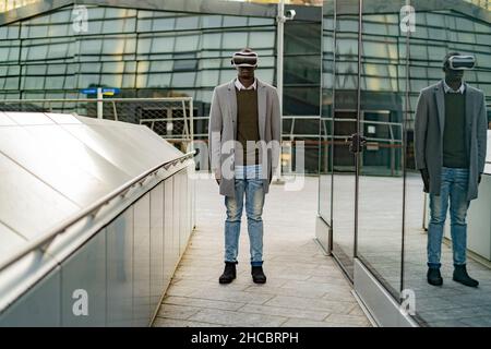 Businessman with virtual reality headset in city Stock Photo