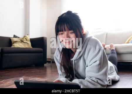 Smiling woman using tablet PC at home Stock Photo
