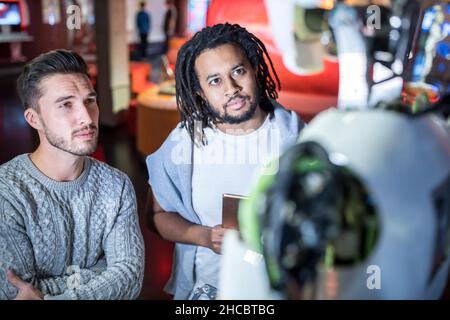 Engineers looking at human robot in workshop Stock Photo