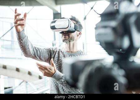Tech developer wearing virtual reality headset at robotic workshop Stock Photo