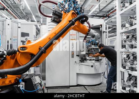 Maintenance engineer repairing robotic arm in industry Stock Photo
