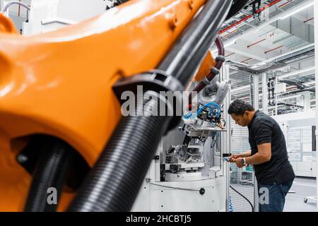 Maintenance engineer repairing robot arm in factory Stock Photo