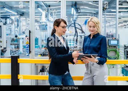 Businesswomen using digital tablet at electrical industry Stock Photo