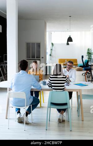 Colleagues sitting at desk working in office Stock Photo