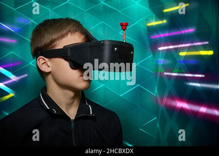 guy in virtual glasses with an antenna in a room with lighting effects. Stock Photo
