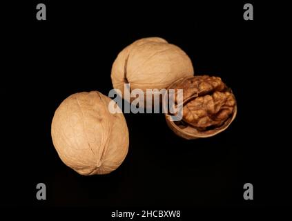 Walnuts on a black background one nut without shell, the concept of healthy eating Stock Photo