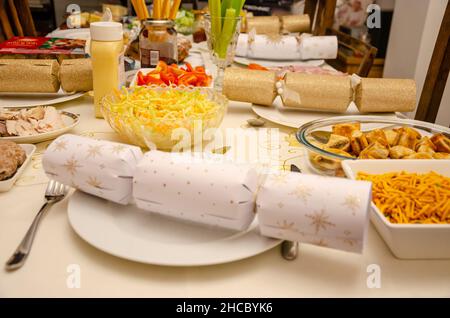 A selection of food on a table laid for a salad for Boxing Day tea, complete with festive Christmas crackers. Stock Photo