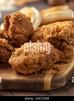 Closeup of crispy fried chicken leg and thigh dinner  on a cutting board Stock Photo