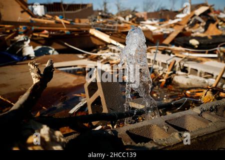 Dawson Springs, USA. 14th Dec, 2021. A broken waterline spews water from the rubble of a home on North 6th Street in Mayfield, Kentucky, Tuesday, Dec. 14, 2021. (Photo by Alex Slitz/Lexington Herald-Leader/TNS/Sipa USA) Credit: Sipa USA/Alamy Live News Stock Photo