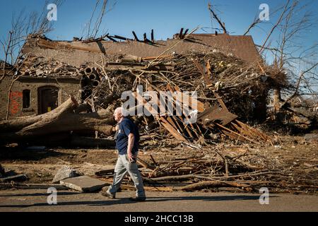 Dawson Springs, USA. 14th Dec, 2021. Retired history professor and Mayfield native Berry Craig, of Arlington, Kentucky, walks past a damaged home along North 6th Street in Mayfield, Tuesday, Dec. 14, 2021. (Photo by Alex Slitz/Lexington Herald-Leader/TNS/Sipa USA) Credit: Sipa USA/Alamy Live News Stock Photo
