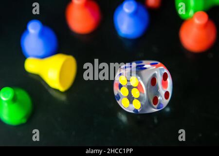 Photo of a clear dice and tokens in a reflective surface Stock Photo
