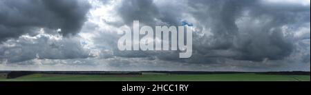 Panorama of gray clouds over green Stock Photo