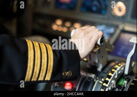 Female pilot's hand on the plane engine control stick. Stock Photo