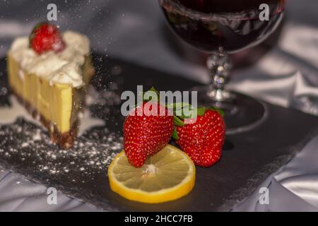 Summer still life with wineglass of champagne, strawberry cheesecake. Intimate romantic celebration in quarantine. A beautiful fresh strawberry layer Stock Photo