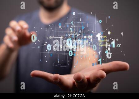 Closeup of the man's hand holding the network connections with binary numbers. Stock Photo