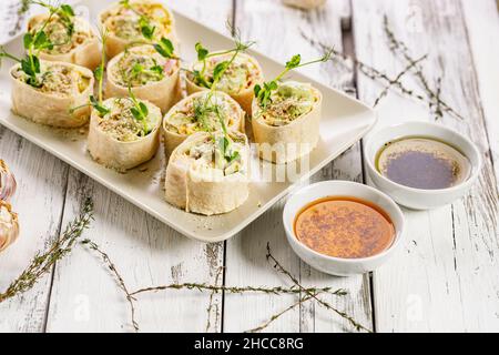 Tortilla deli wrap rolls with chicken ham and vegetable. White rustic background. Olive oil with tomatoes and basil. Wheat sandwich rolls with chicken Stock Photo