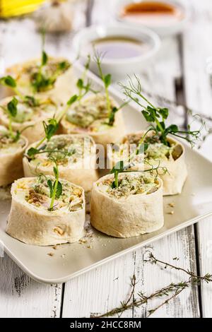 Tortilla deli wrap rolls with chicken ham and vegetable. Wheat sandwich rolls with chicken, cheese, cucumber, fresh herbs and salad. White background Stock Photo