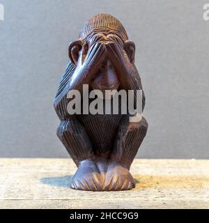 Closeup of a monkey statue covering its eyes Stock Photo