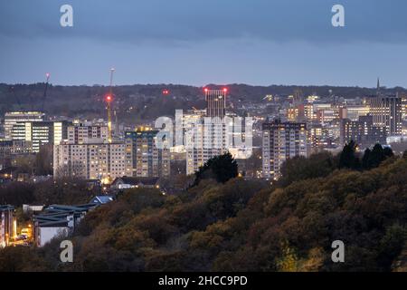 The skyline of Bristol city centre is lit at dusk, as viewed from Trooper's Hill. Stock Photo