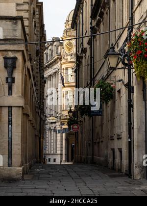 The grand Baroque Midland Bank building is glimpsed between the buildings of St Nicholas Market on Old Post Office Passage in Bristol. Stock Photo