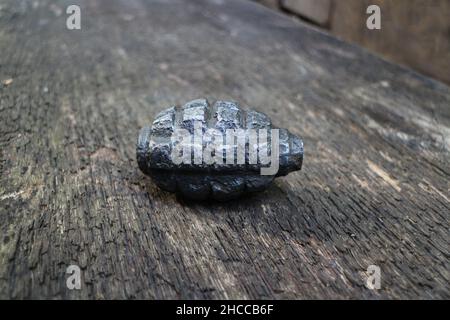rusty hand grenade on textured wooden surface Stock Photo