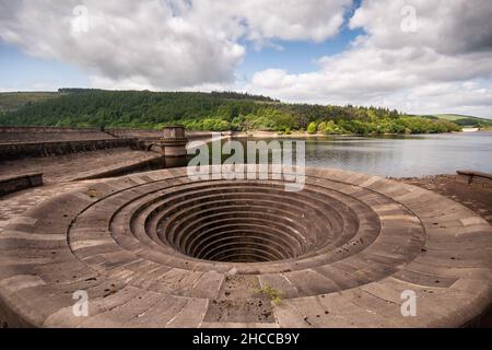 The stone dam and spillway of Ladybower Reservoir in the Derwent Valley, under the hills of Derbyshire's Peak District. Stock Photo