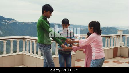 Group of young South Asian friends holding hands with a mountainous background in India Stock Photo