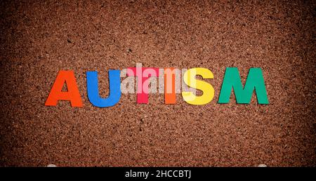 Autism. Autism spectrum disorder. Autism word made out of cardstock. Cork board background. Close up. Stock Photo