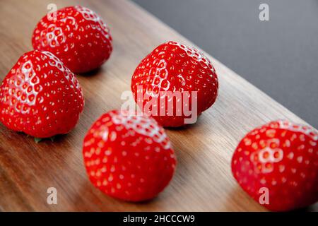 Strawberries on a wooden cutting board. Black background Stock Photo