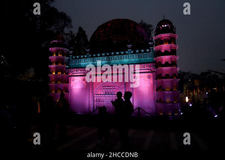 New Delhi, India. 26th Dec, 2021. Visitors take pictures of a replica of Gol Gumbaz at Bharat Darshan Park in New Delhi. The park has replicas of several iconic monuments of India built with scrap and waste material. Credit: SOPA Images Limited/Alamy Live News Stock Photo