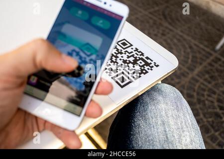 Valencia, Spain; 7th november 2021: A man scans a QR code with his smartphone at a restaurant. One of the anticovid measures adopted in Spain is the r Stock Photo