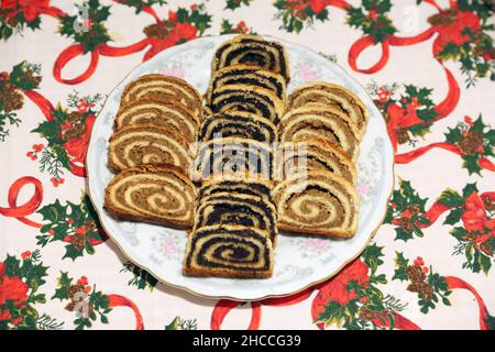 Homemade poppy seeds or walnut roll cakes aka beigli or bejgli slices like a winged angel on plate. Traditional hungarian christmas sliced rolled cake Stock Photo