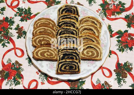 Homemade poppy seeds or walnut roll cakes aka beigli or bejgli slices like a winged angel on plate. Traditional hungarian christmas sliced rolled cake Stock Photo