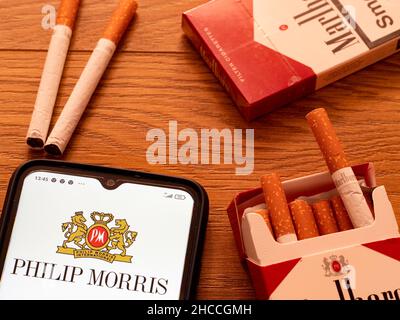 Ukraine. 26th Dec, 2021. In this photo illustration Philip Morris International Inc. logo seen displayed on a smartphone and packs of Marlboro Cigarettes. (Photo by Valera Golovniov/SOPA Images/Sipa USA) Credit: Sipa USA/Alamy Live News Stock Photo